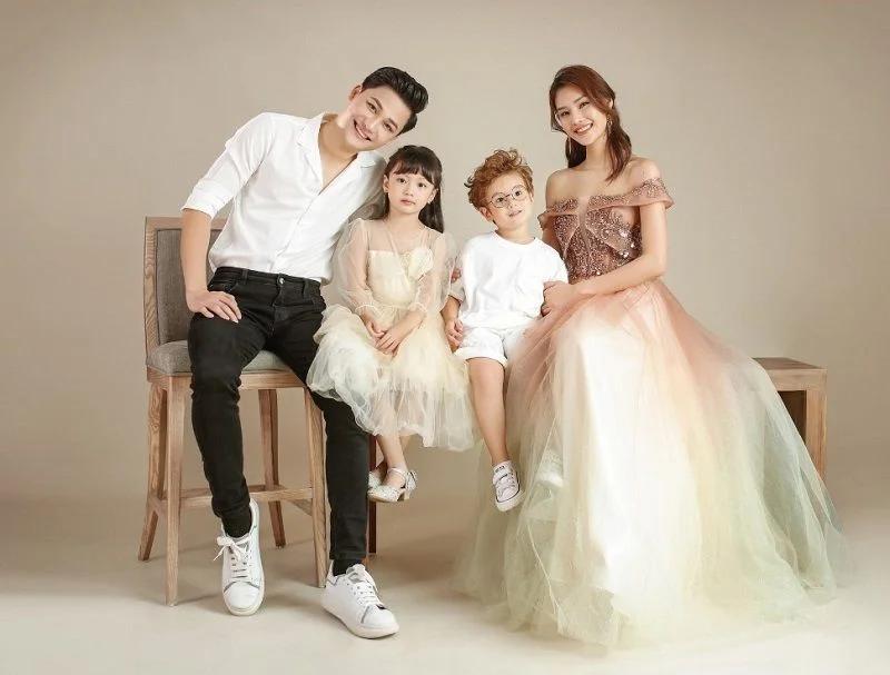 Gia đình bốn người tạo dáng vui vẻ trong studio