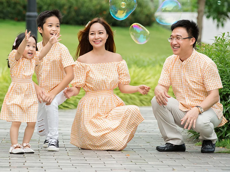 Gia đình bốn người vui chơi ngoài trời cùng bong bóng xà phòng
