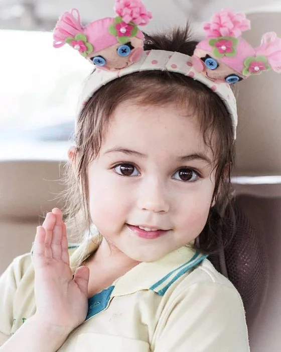ảnh em bé cute đội khăn đính tai thú nhìn máy ảnh