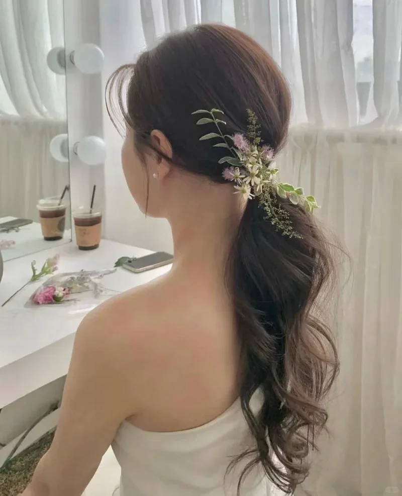 Nữ tóc xoăn lato trang trí nhánh hoa trên vai